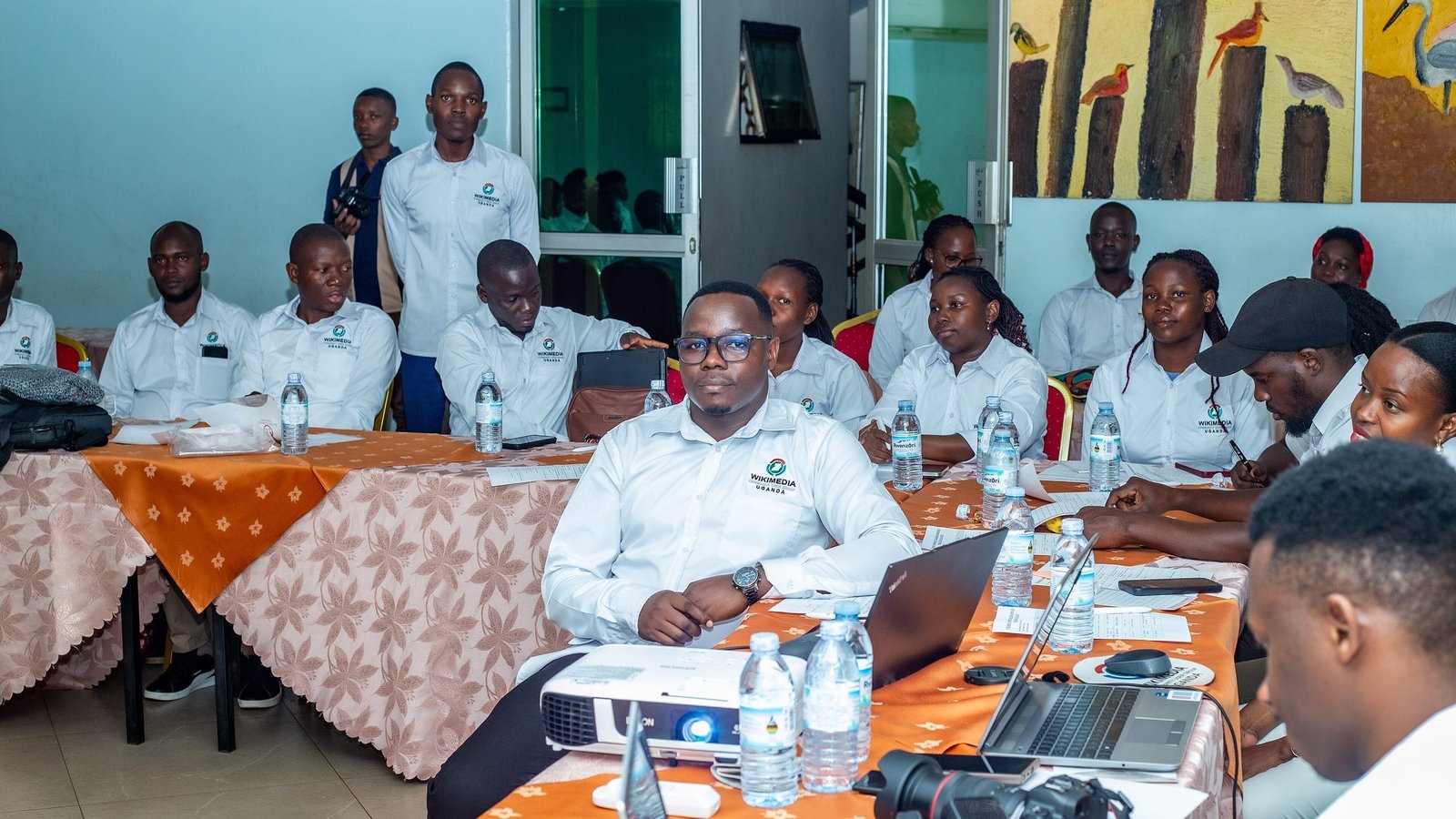 Members of a community organisation seated around a table during an annual general meeting