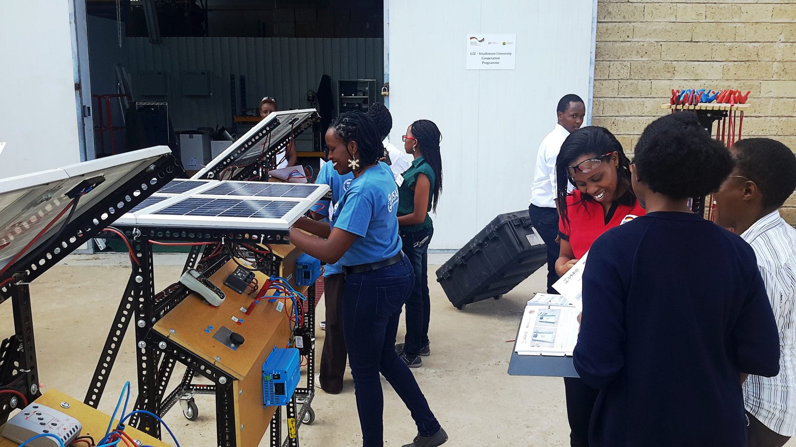 Trainees gathered around solar equipment at a technical training centre